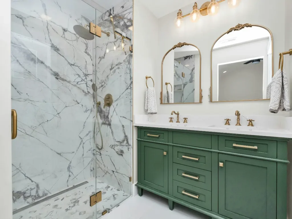 Bathroom remodel design inspiration featuring a marble walk-in shower, green vanity, and brass fixtures