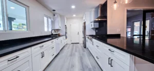 Modern white kitchen expansion remodel in Oakland, CA with black countertops and custom cabinetry