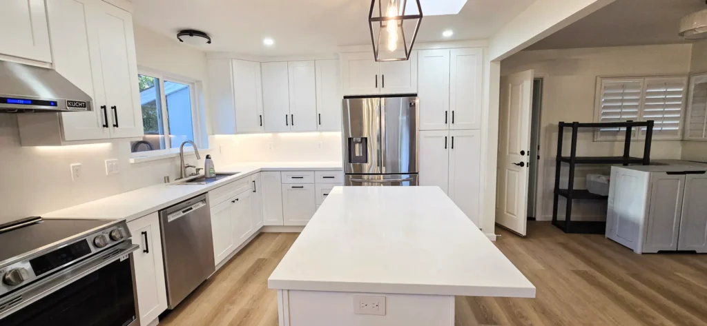 Kitchen remodel in Santa Clara featuring white shaker cabinets, quartz island, stainless steel appliances and wood flooring by Lions Gate Remodeling