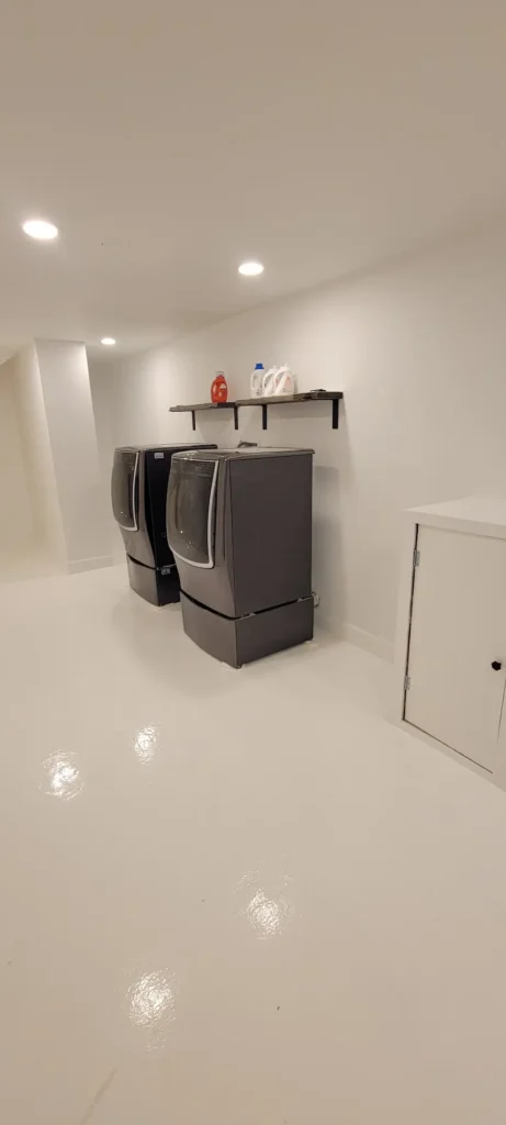Remodeled laundry room with epoxy flooring and washer dryer setup in El Sereno California
