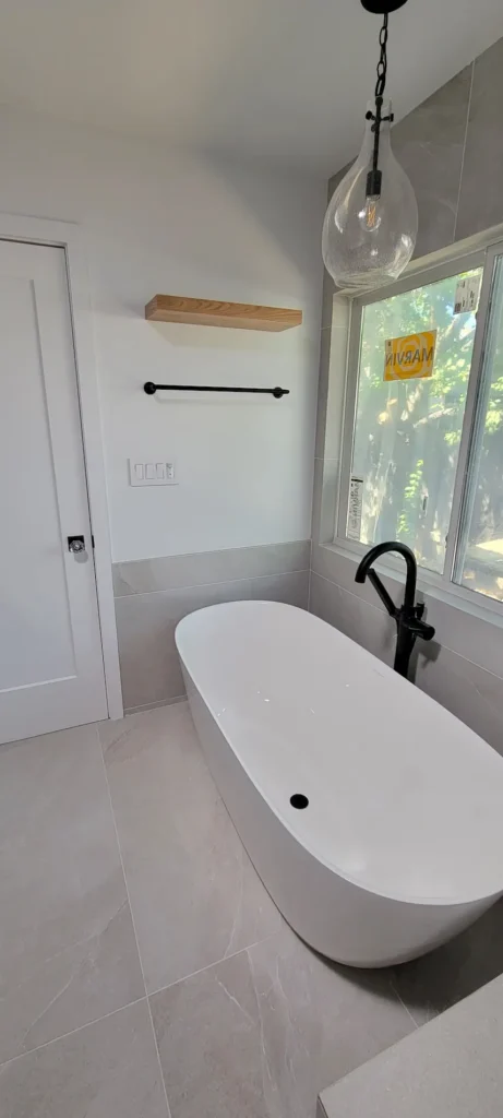 Freestanding soaking tub in a new master bathroom addition in Martinez California with modern fixtures and natural light
