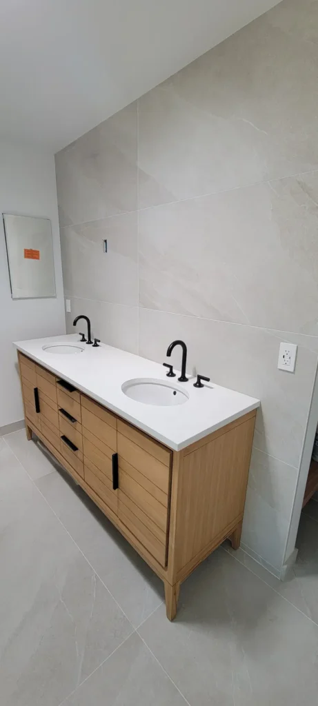Double sink vanity in a custom master bathroom addition in Martinez California with wood cabinetry and matte black fixtures