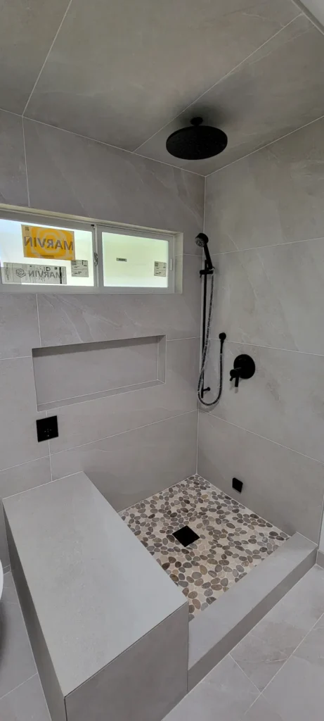 Custom walk in shower in a master bathroom addition in Martinez California with rainfall shower head and built in shower niche