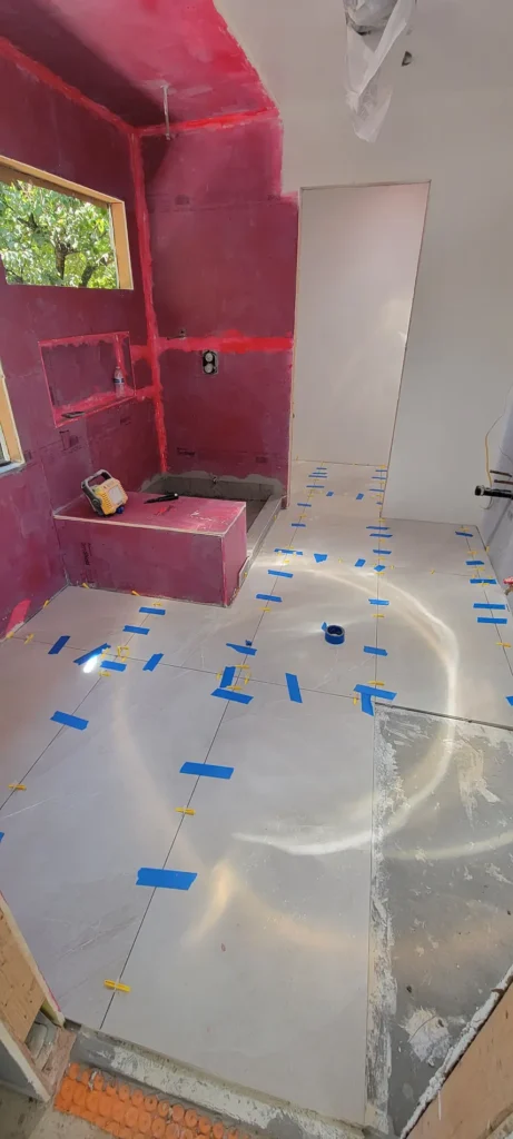 Bathroom tile installation during a master suite addition in Martinez California showing waterproof shower walls and large format floor tile