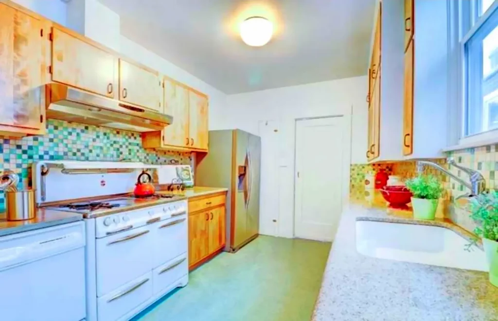 Before kitchen remodel in Walnut Creek showing an outdated galley kitchen with older cabinets, appliances, and tile backsplash