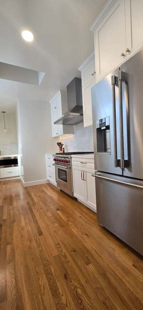 Finished Walnut Creek kitchen remodel with white shaker cabinets, stainless steel appliances, hardwood floors, and skylight bringing in natural light