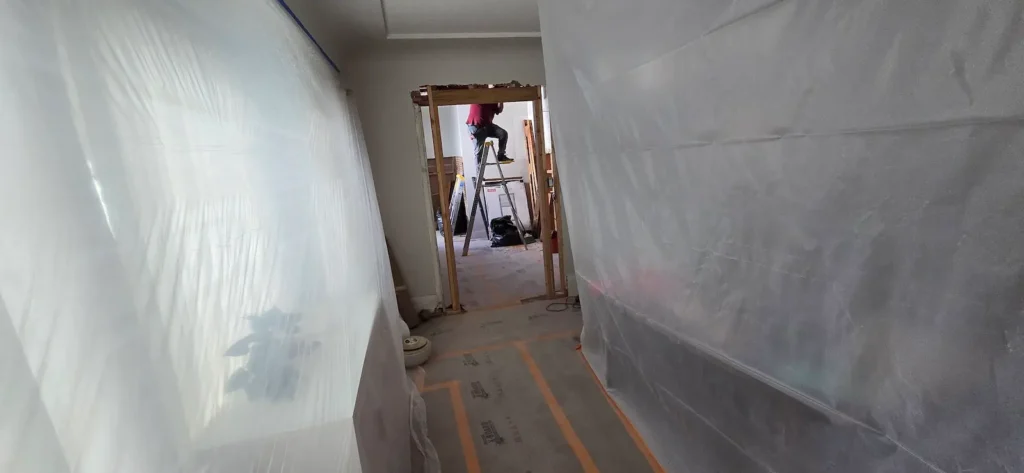 Kitchen remodel demolition in Walnut Creek with plastic dust barriers and framing exposed during renovation