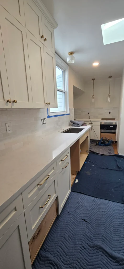 Walnut Creek kitchen remodel during installation with white shaker cabinets, brass hardware, and tile backsplash being completed