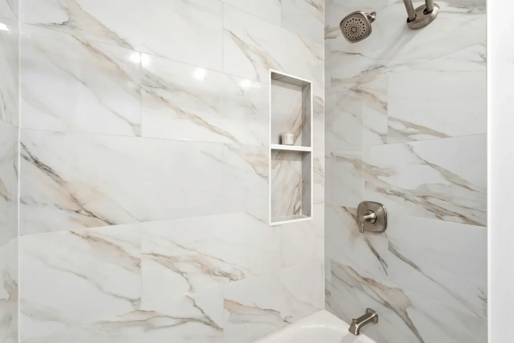 Built-in shower niche with marble-look porcelain tile.