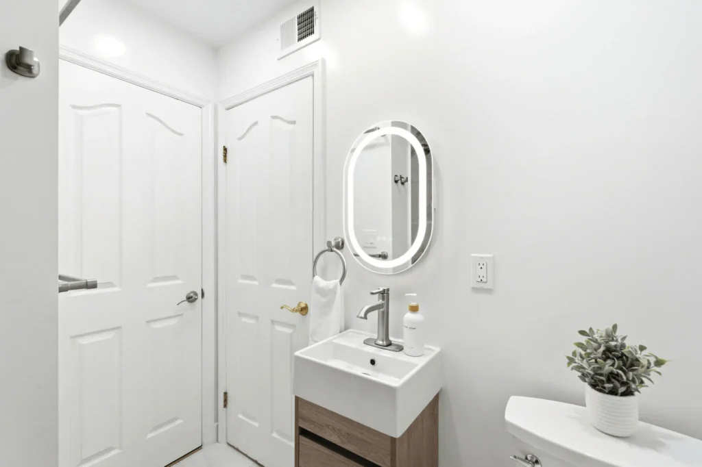 Backlit LED mirror installed above a floating vanity.